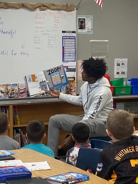 Senior Vince Dawson reads a story to students as part of the mentor program.  